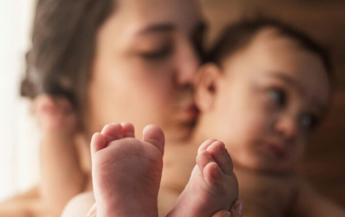 Madre abrazando a su bebé en el postparto, reflejando la importancia de la psicología perinatal y la salud mental materna