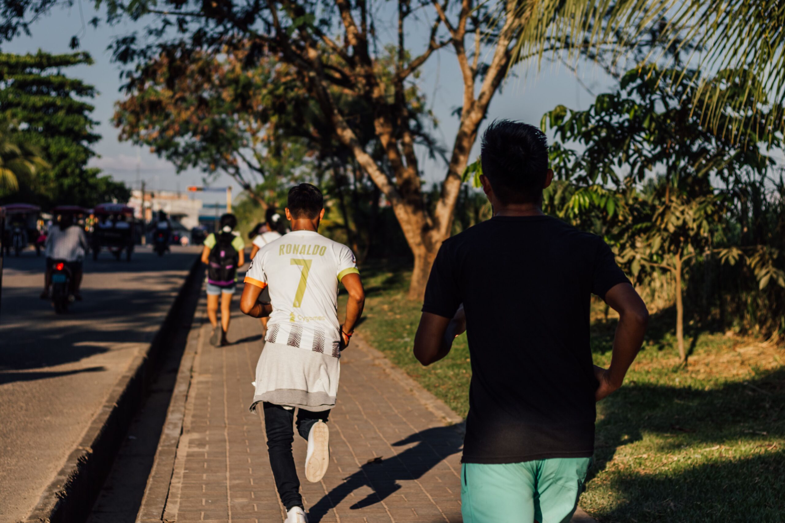 Dos personas corriendo en un parque, retomando el running en otoño tras el verano